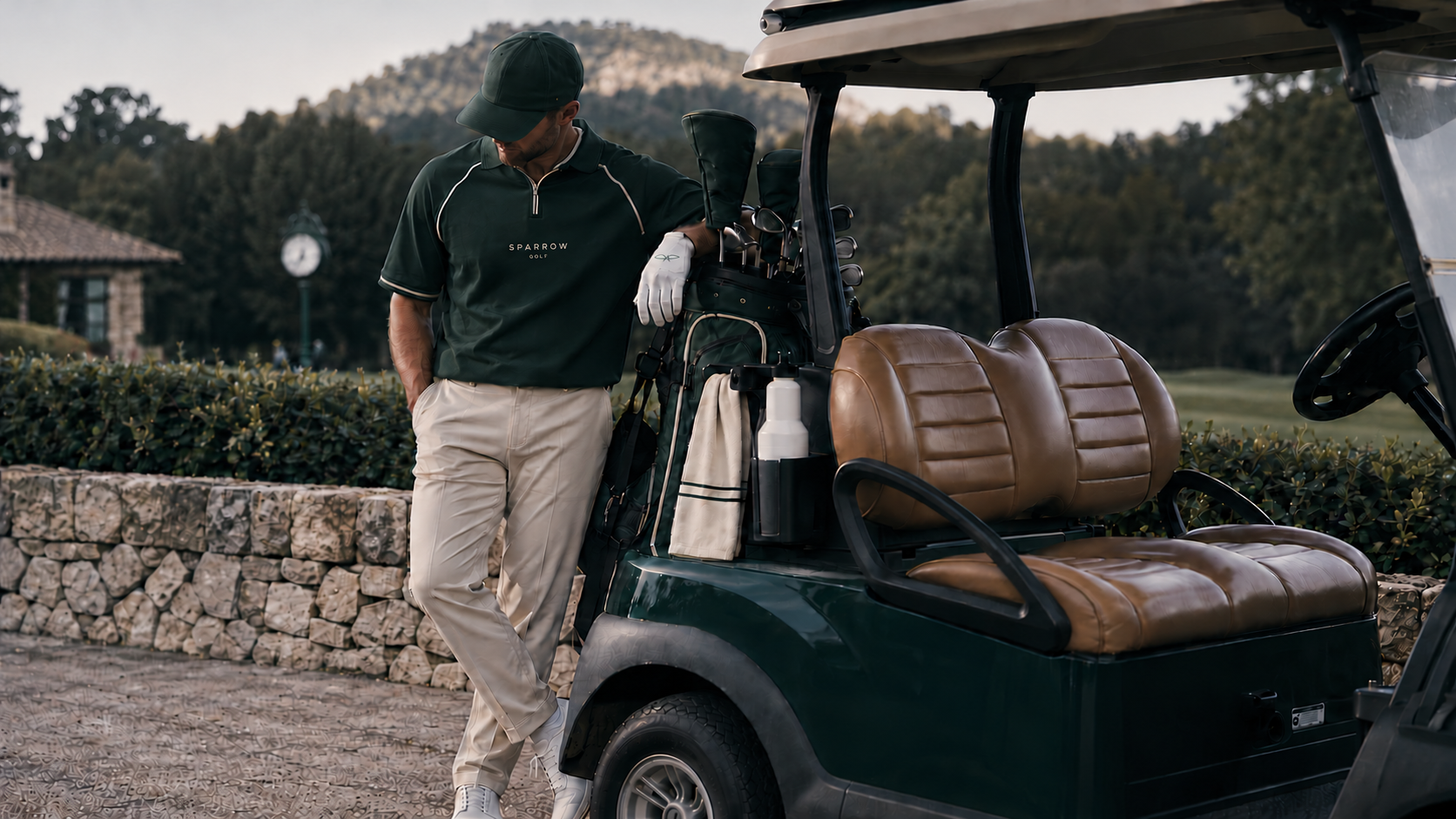 A golfer in the Heritage Green polo, paused beside a cart on a British course.